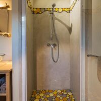 Douche de la chambre d'hôtes avec lit simple et les galets colorés d'Alun Bacon chambre d'hôtes Entre Ciel et Pierres Vercors