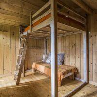 A l'intérieur, lit double en haut, lit simple en bas cabane de la forêt